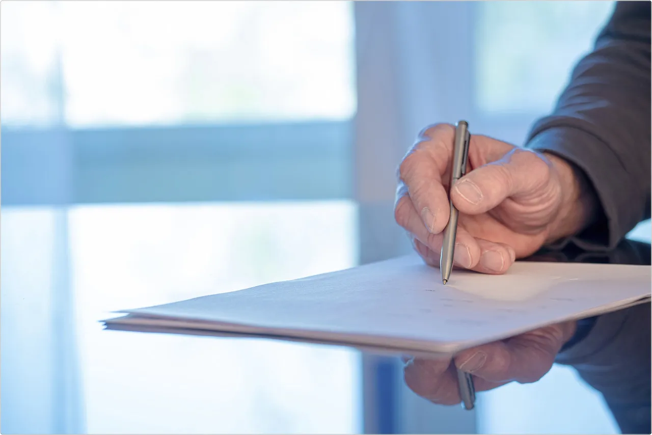 형사 사건 관련 법률 문서에 서명하며 변호사 상담을 진행하는 모습